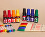Set of colorful markers and pens on a beige background