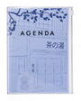A light blue planner or agenda cover with a line-art illustration of a Japanese storefront, featuring the word 'AGENDA' and Japanese text, shown on a plain white background.