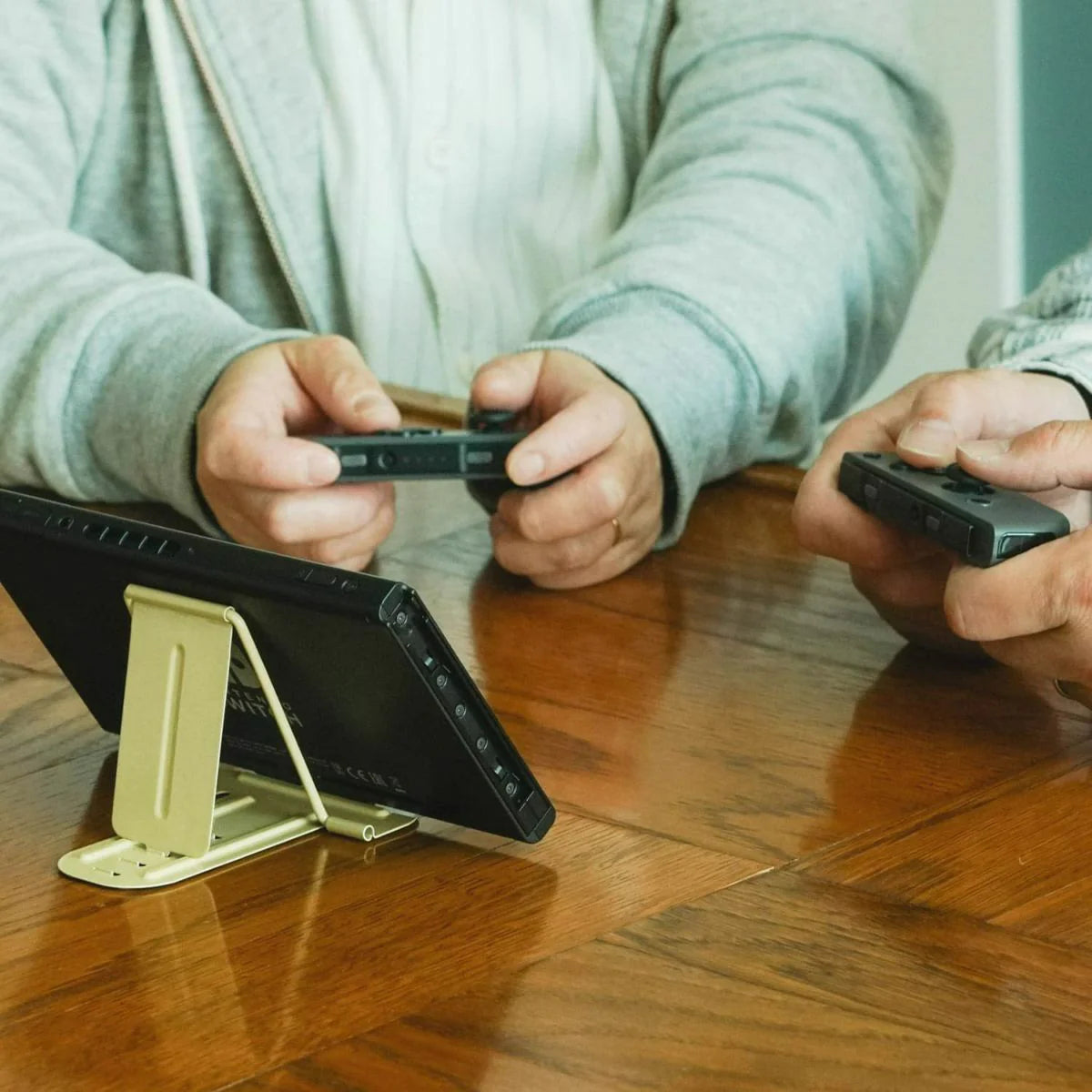 Metal Gadget Stand holding Nintendo Switch while two players play