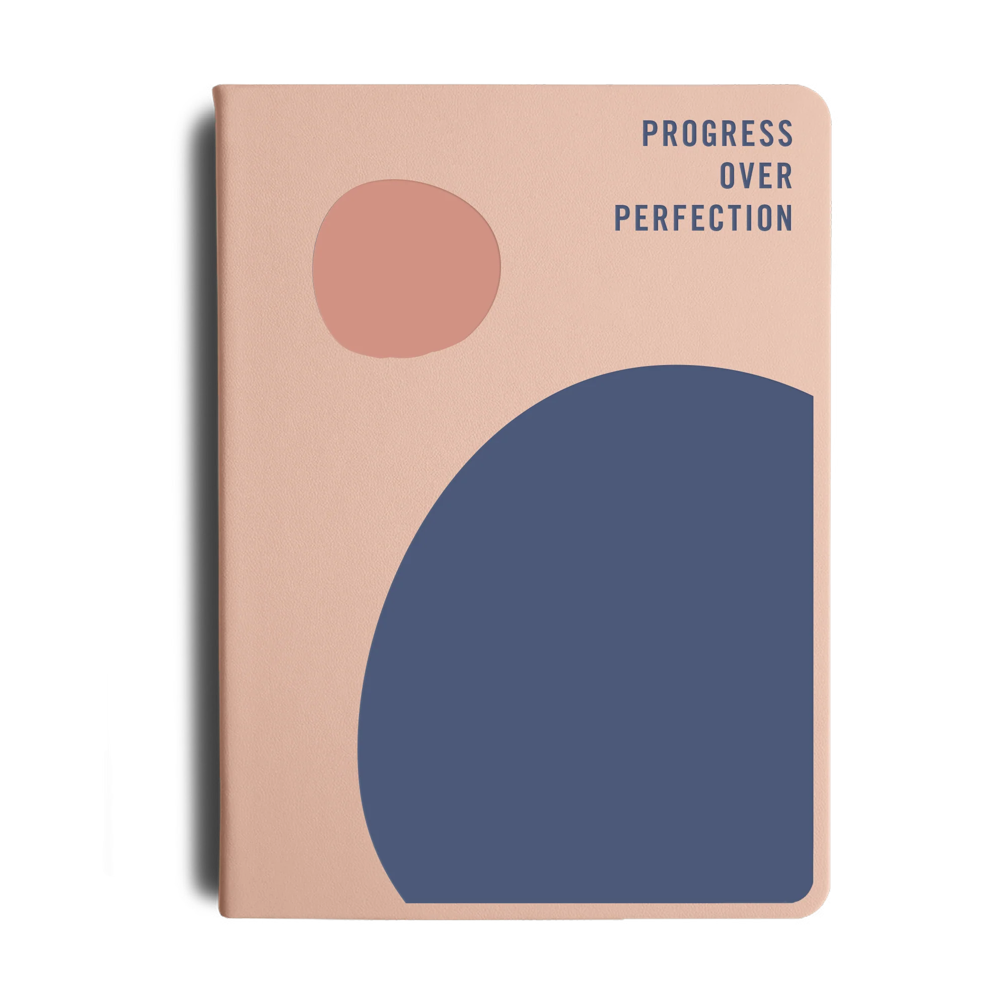 Notebook with abstract shapes and 'Progress Over Perfection' text on a beige background