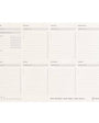A beige weekly desk pad with a 7-day spread, including Monday to Saturday, with Sunday being a new weekly goal section.