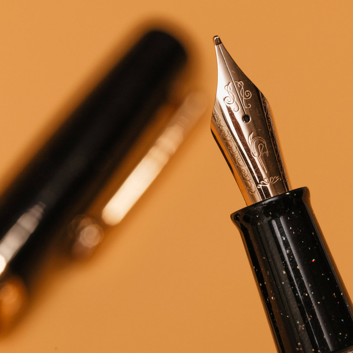 Close-up of a fountain pen with detailed nib on a warm brown background