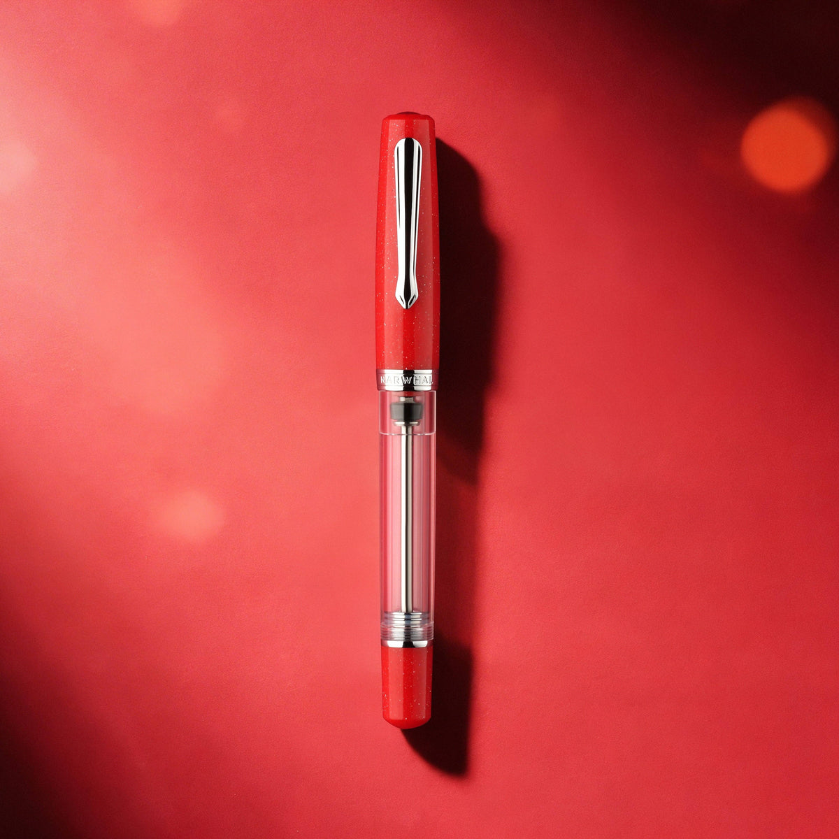 Red pen with a clear cartridge on a red background