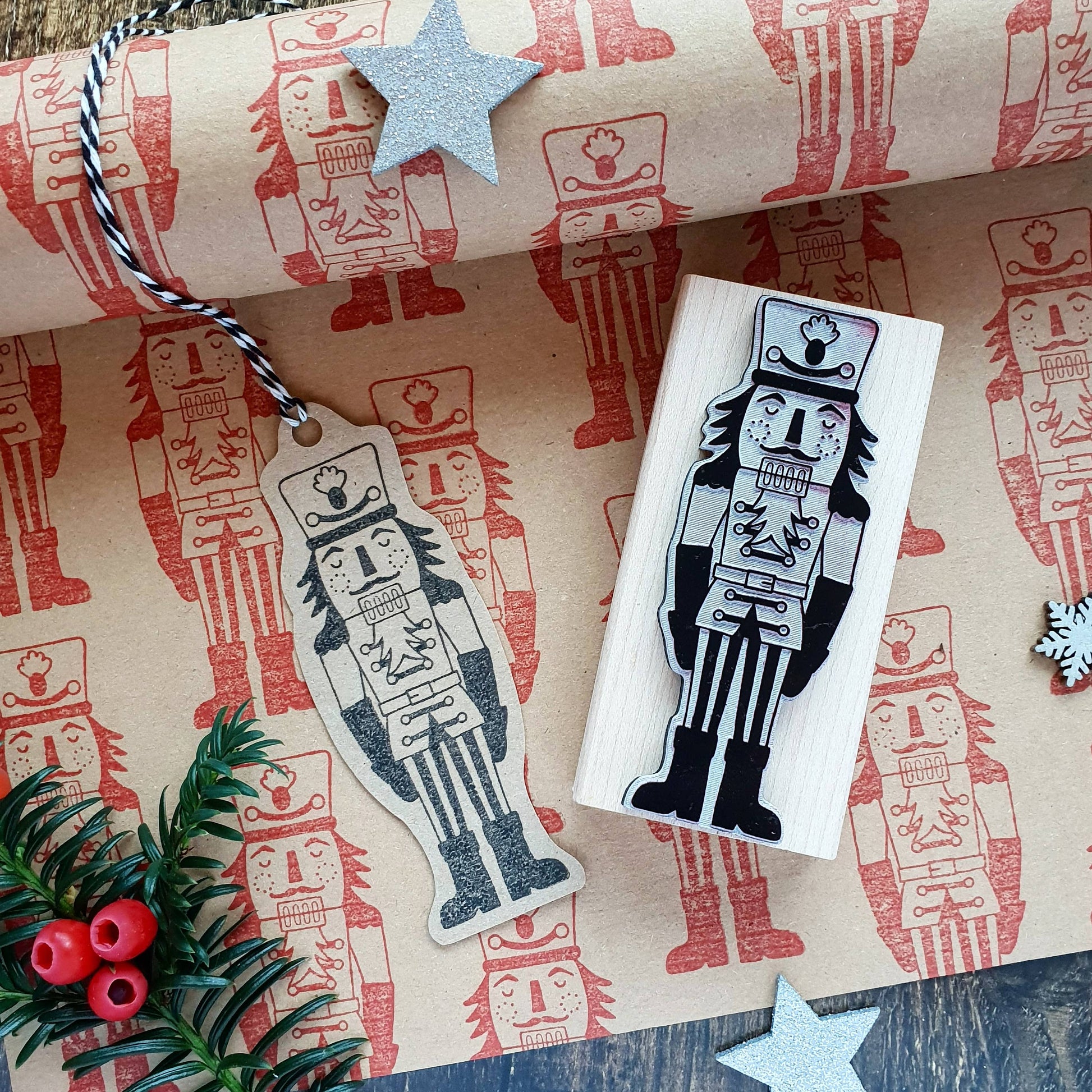 Wooden nutcracker stamp and matching tag on a decorative paper background