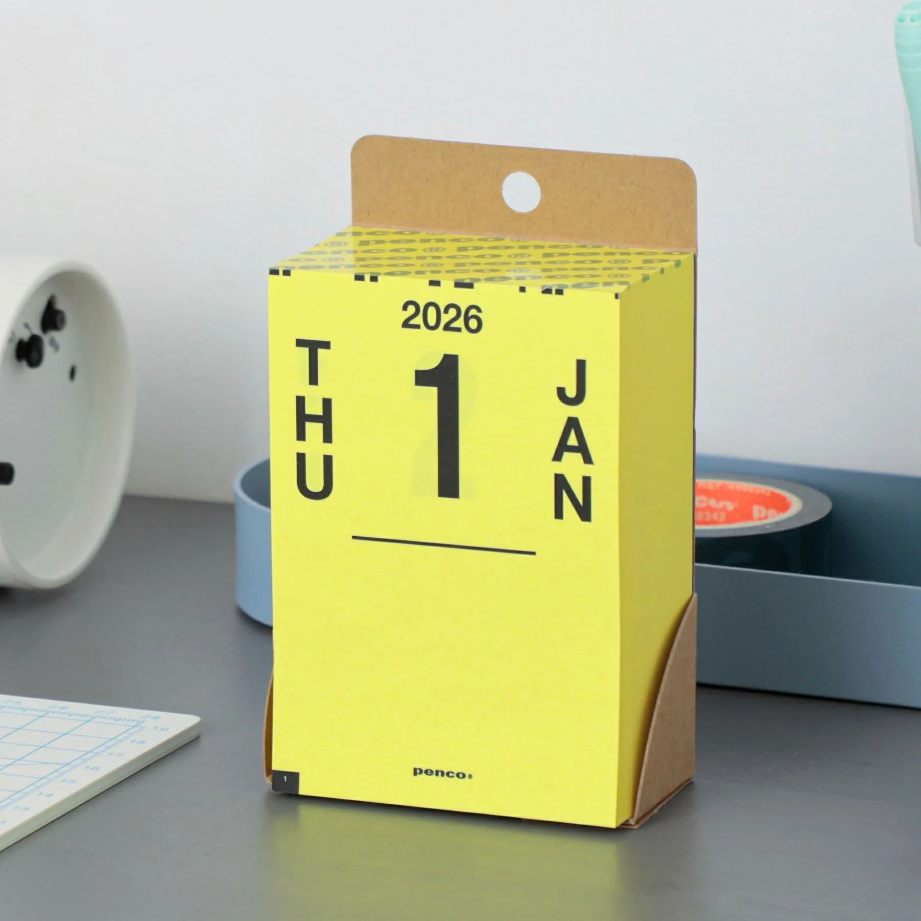 Yellow daily planner with '2026' and '1 Jan' on a gray surface