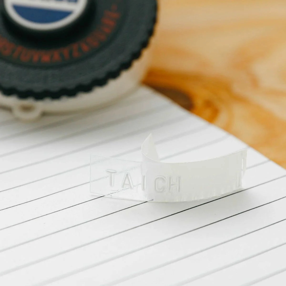 White rubber stamp with 'LACH' branding on a wooden surface