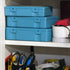 Stack of blue toolboxes on a shelf with various tools and equipment around.