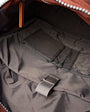 Close-up of a backpack interior with a brown zipper and gray lining.