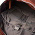 Close-up of a backpack interior with a brown zipper and gray lining.