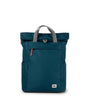 A medium-sized teal ROKA Finchley backpack with a roll-top closure, a large front pocket with zip, and two side handles.