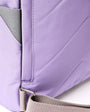 close up shot of lavender coloured backpack showing straps on a white background