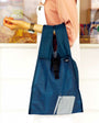 Blue reusable shopping bag held by a person in a kitchen setting