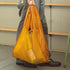 Person holding a yellow reusable bag with a visible brand logo.