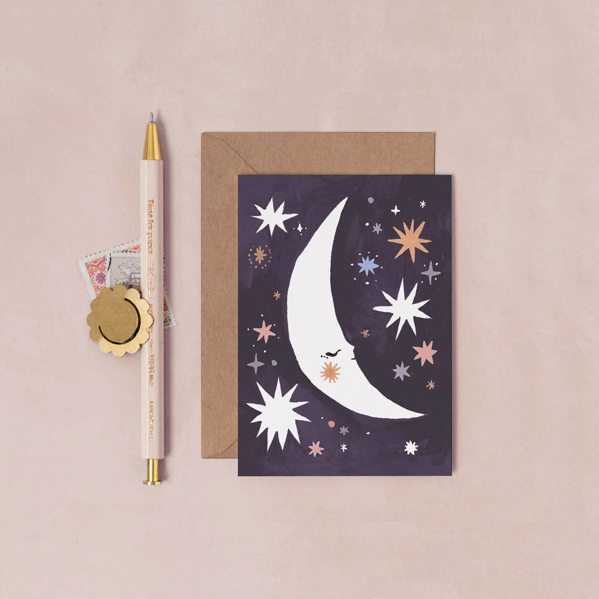 Greeting card with moon and star design on a beige background
