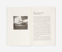 Open book with a black and white photograph on the left page and text on the right page.