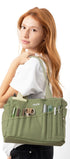 Woman holding a green bag with various compartments on a white background