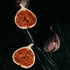 Figs, including a halved fig showing its interior, on a dark surface.