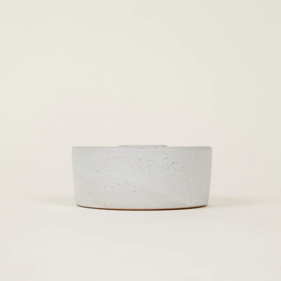 Speckled gray ceramic bowl on a beige background