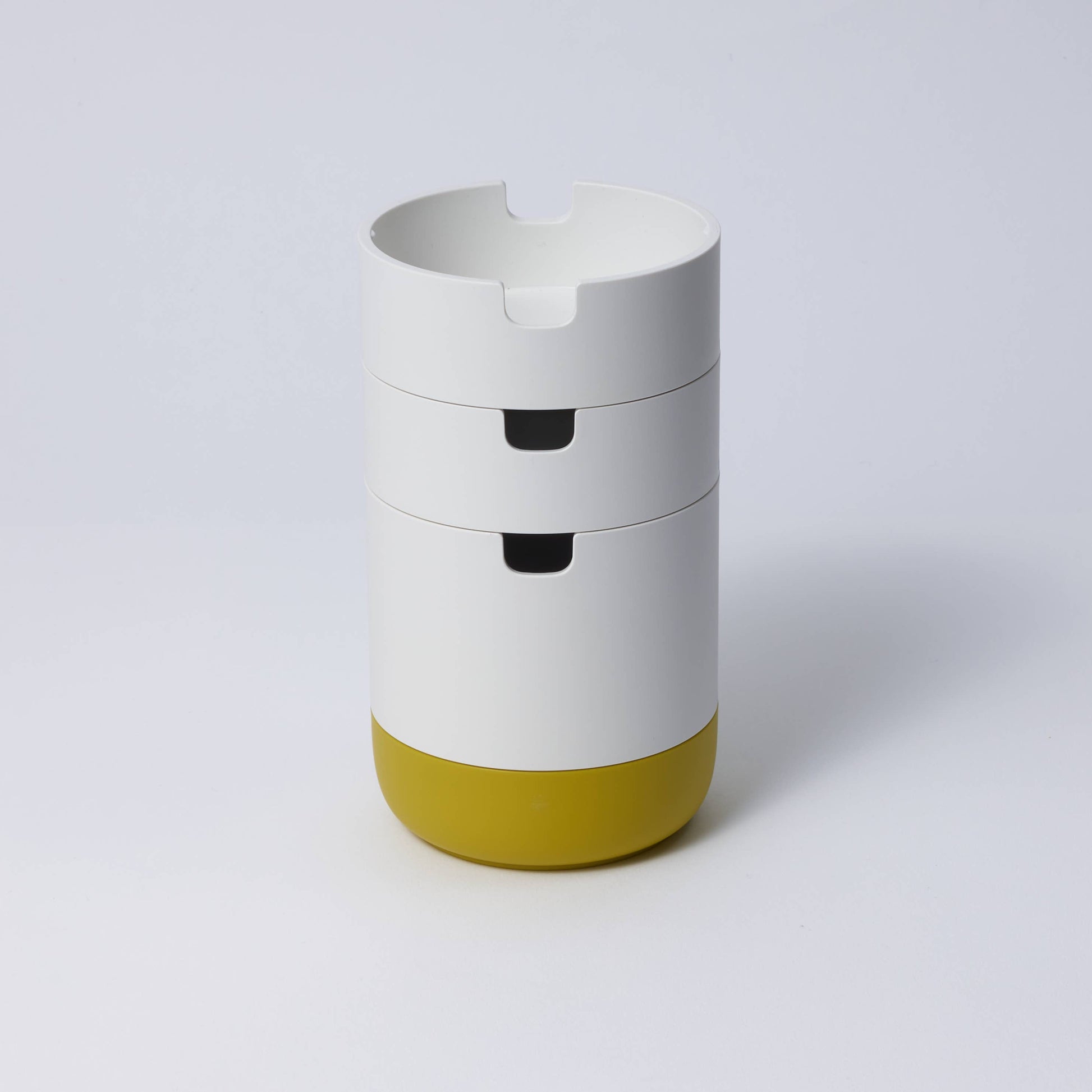 A collection of stackable organizer cases in various colors with a matte porcelain-like finish, designed to hold stationery items.