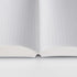 Open notebook with grid-patterned pages on a white background