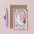 Greeting card with a stork and baby illustration, text 'Welcome Little One', and a pen on a pink background