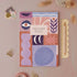 Weekly planner with abstract geometric design on a pink background with stationery items.