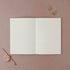 Open notebook with lined pages on a pink background