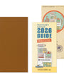 Brown notebook with a yellow cover featuring 'Traveler's notebook 2026 Guide' and a circular sticker on a white background.
