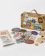 Travel-themed kit with stickers, notebook, and decorative items on a white background