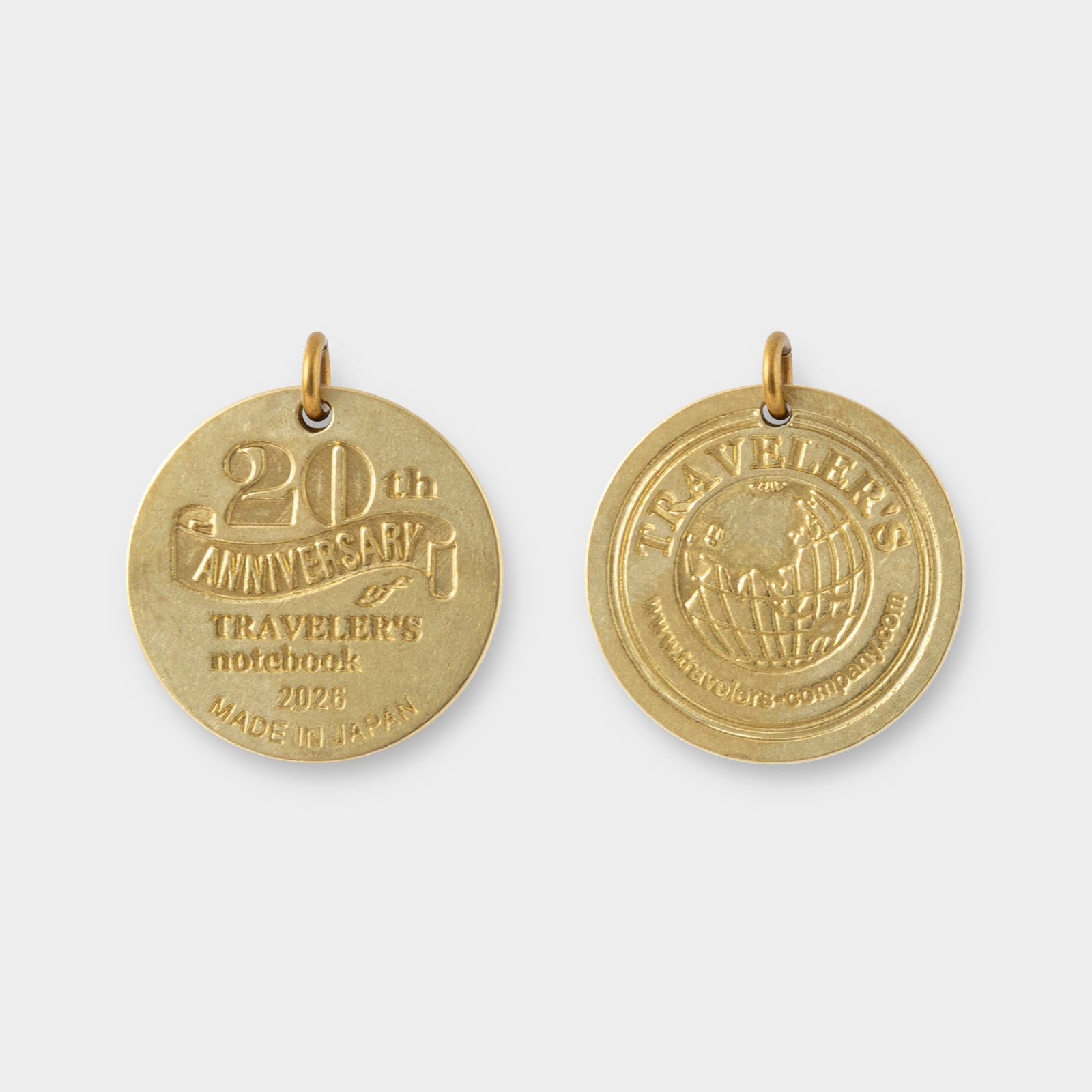 Two gold travel-themed pendants on a white background