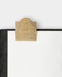 Gold metal clasp on a black notebook with 'Traveler's Company' branding.
