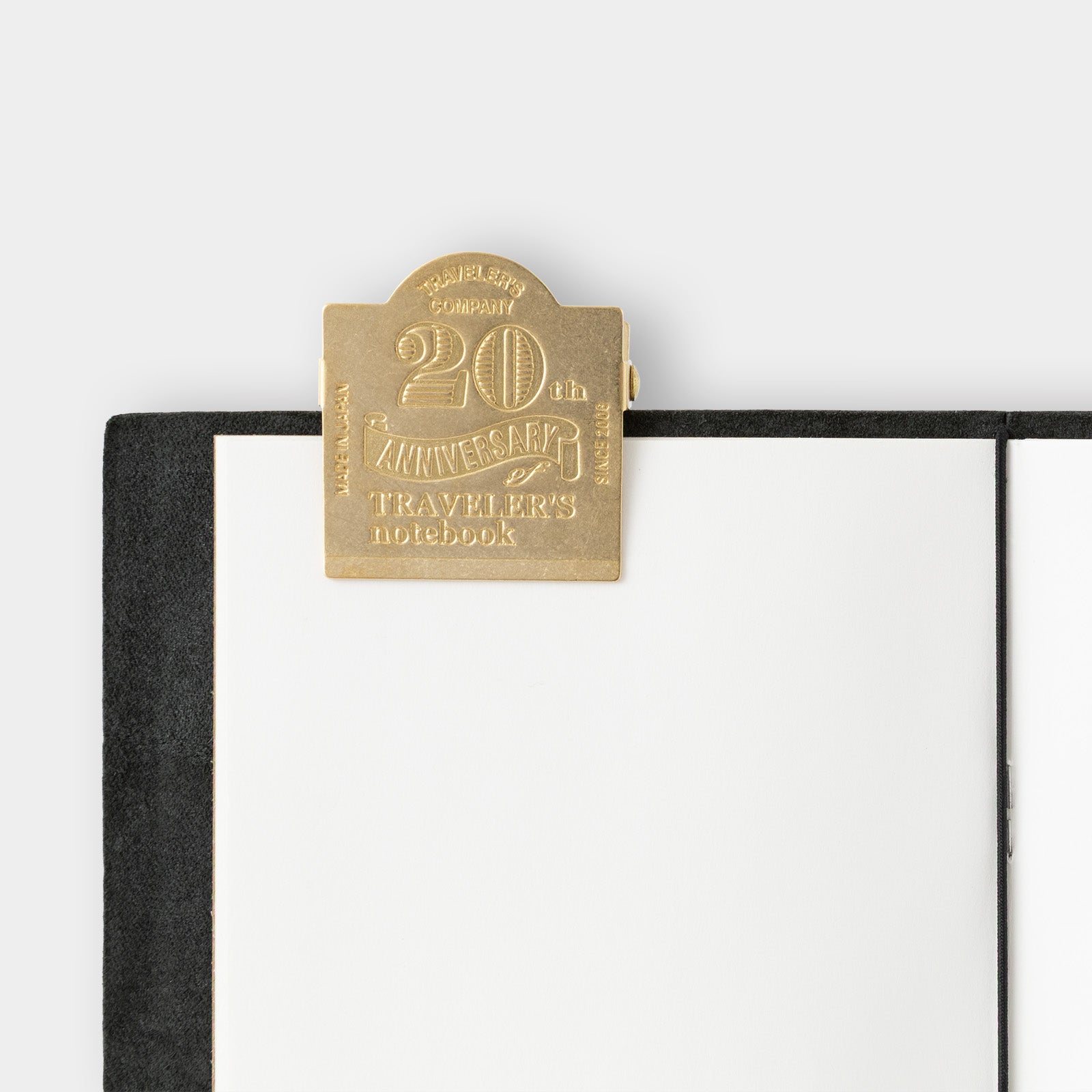 Gold metal clasp on a black notebook with 'Traveler's Company' branding.