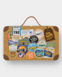 Brown suitcase with various travel-themed stickers on a white background