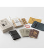 Collection of leather-bound notebooks and accessories on a white background