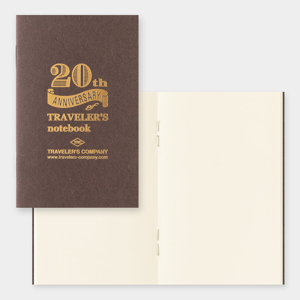 Brown notebook with gold text '20th Anniversary Traveler's notebook' on a white background