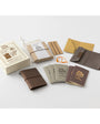 Collection of leather-bound notebooks and accessories on a white background