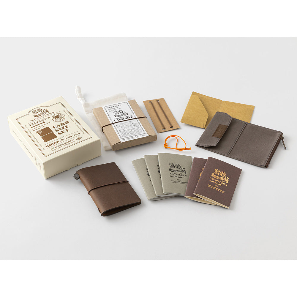 Collection of leather-bound notebooks and accessories on a white background