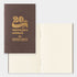Brown notebook with gold text '20th Anniversary Traveler's notebook' on a white background