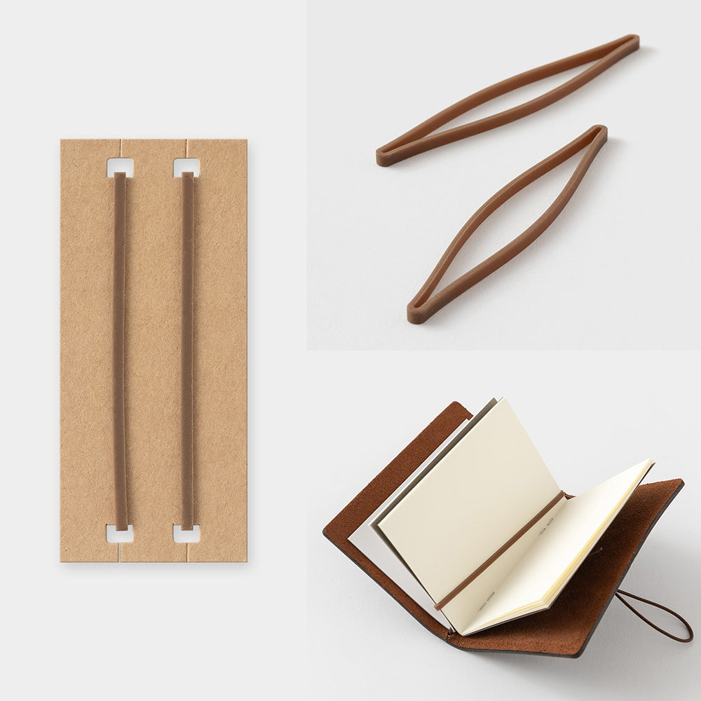 Brown leather notebook with open pages, cardboard holder, and wooden tongs on a white background