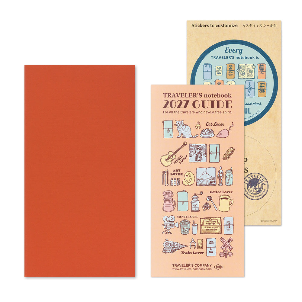 A travel-themed notebook sticker set by Traveler's Company, featuring a solid orange-red notebook cover, a peach-colored '2027 Guide' sticker sheet with travel illustrations, and a beige backing card.