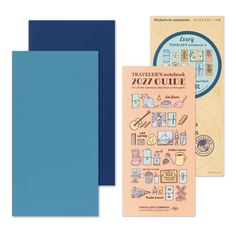Traveler's notebook set featuring a light blue and dark blue notebook cover, a beige sticker sheet with travel-themed illustrations, and a peach-colored 2027 guide booklet.