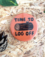 Button badge with 'Time to log off' text on a wooden background