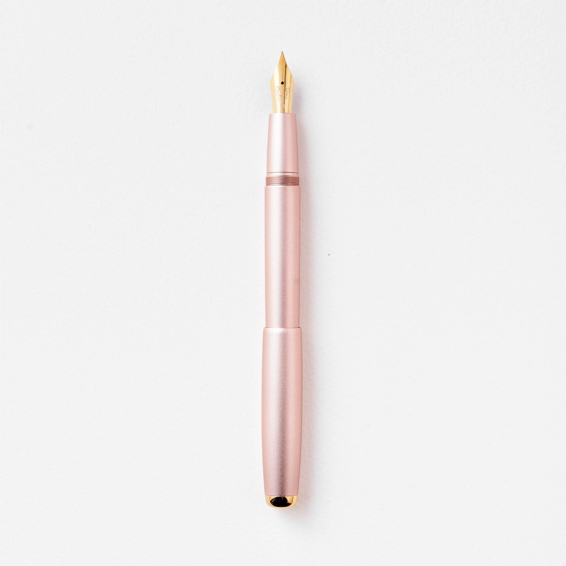 Rose gold fountain pen on a white background