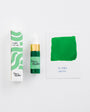 Green ink bottle with packaging and color swatch on a white background