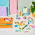 Colorful stationery items including markers, pens, and post-it notes on a white surface with a plant in the corner.