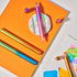 Colorful markers on an orange surface with a white background