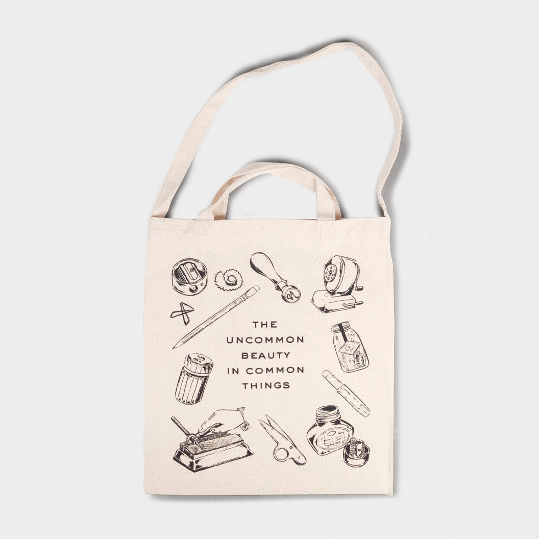 Tote bag with illustrations and text on a light gray background