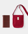 Red shoulder bag with a matching pouch on a white background