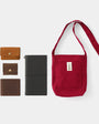 Red shoulder bag with wallets and a black case on a white background