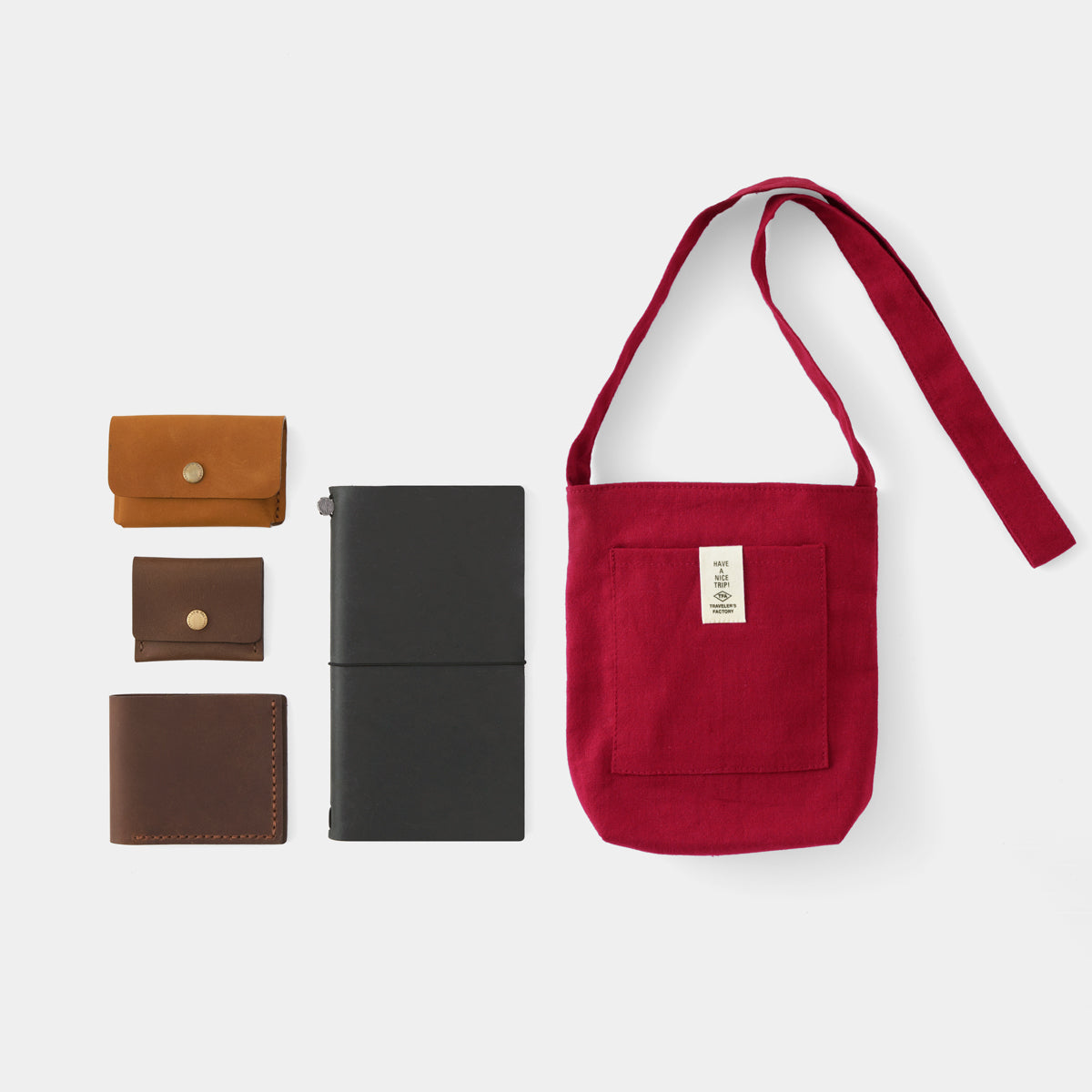 Red shoulder bag with wallets and a black case on a white background
